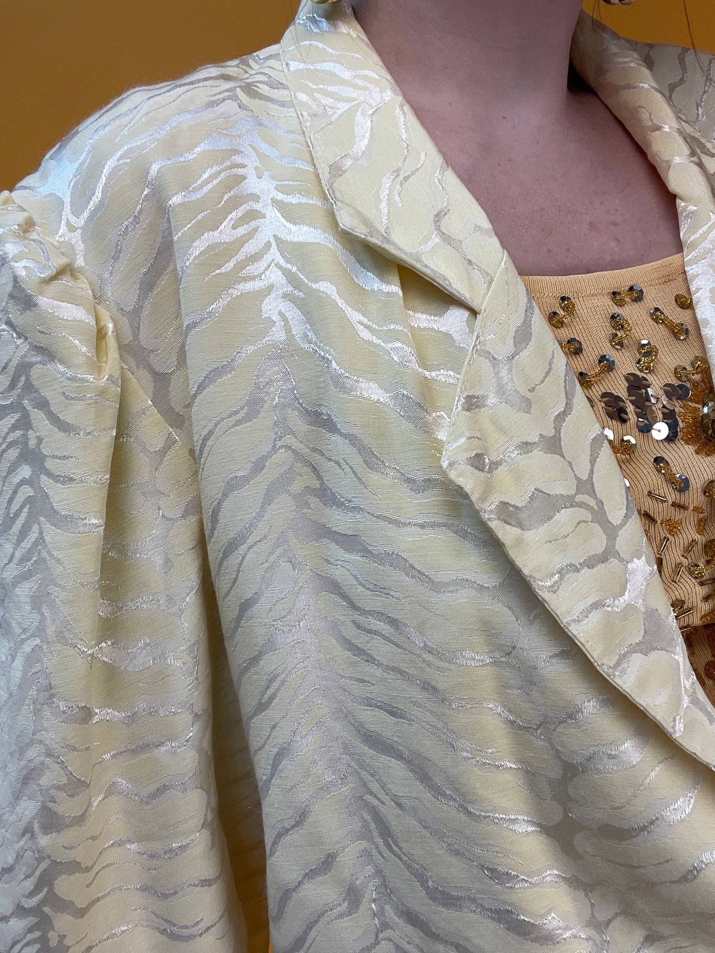 Pastellgelbes Blusenjäckchen mit schimmerndem Tigerwebmuster