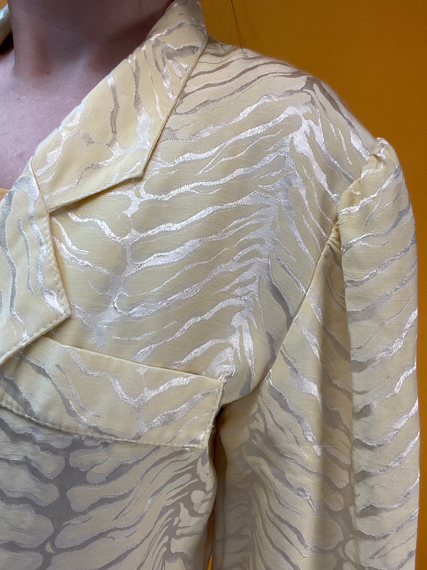 Pastellgelbes Blusenjäckchen mit schimmerndem Tigerwebmuster