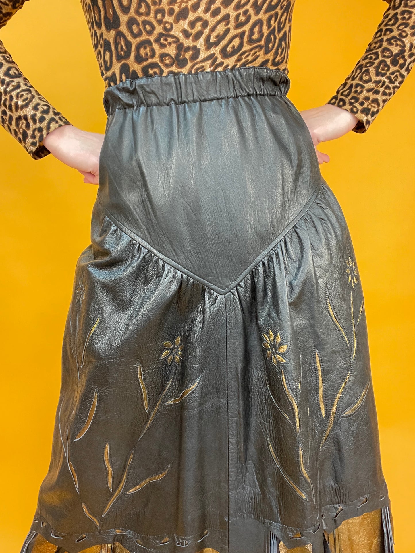 Glamouröser 80s Westernrock aus Leder mit goldfarbenen Akzenten und Fransenbesatz