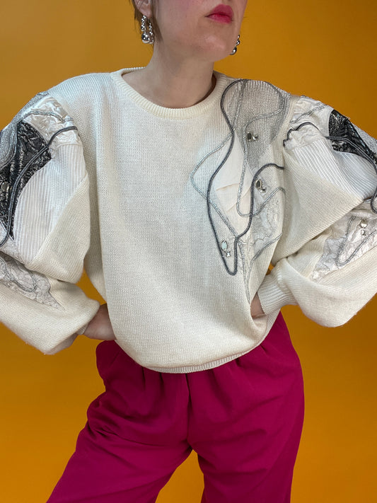 Weißer 80s Strickpulli mit dramatischen Metallicärmeln